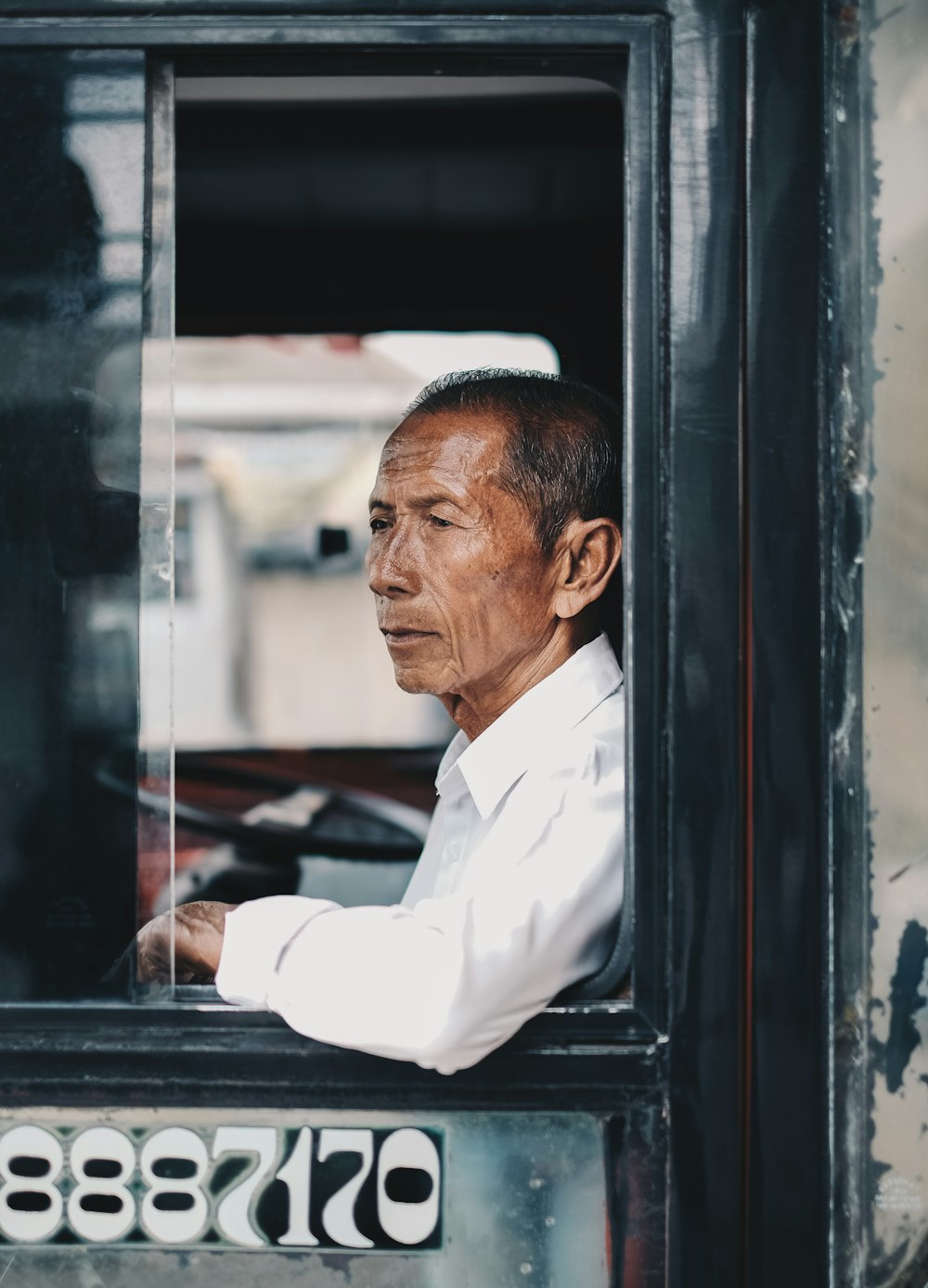 man sitting inside car window