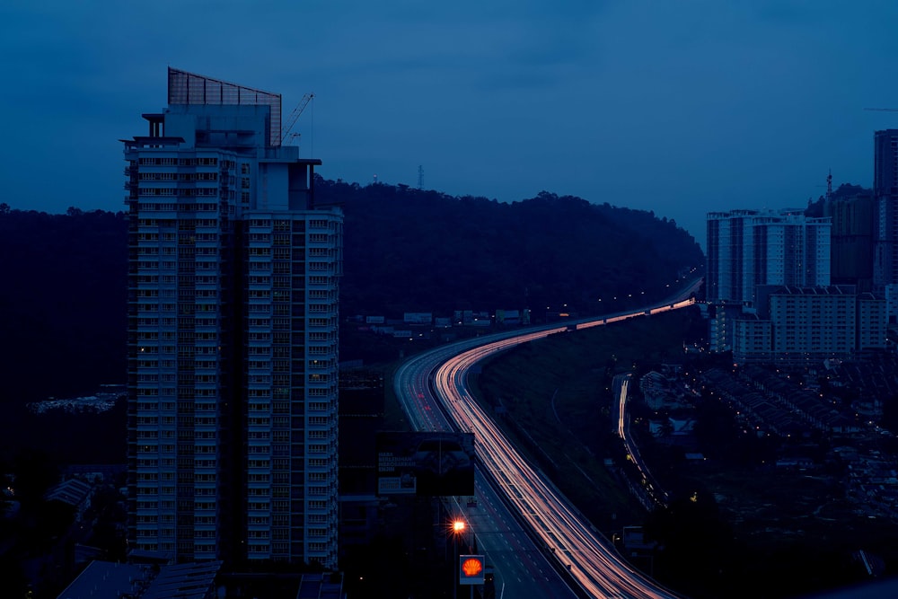 time-lapse photography of vehicles running on highway passing buildings