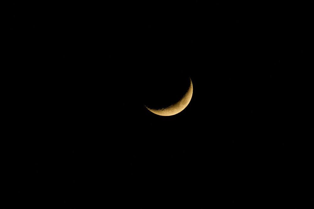 crescent moon in dark sky during nighttime
