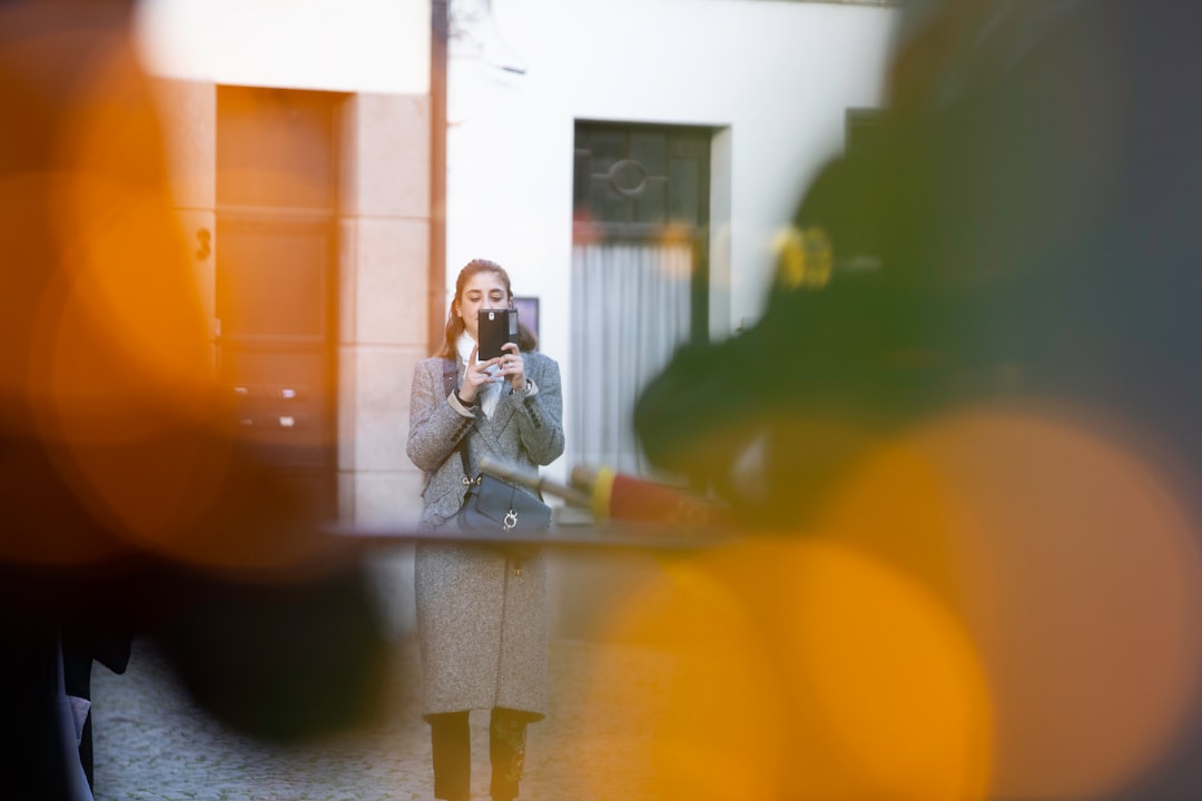 selective focus photography of woman using black smartphone