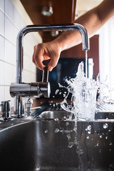 person turning on kitchen tap