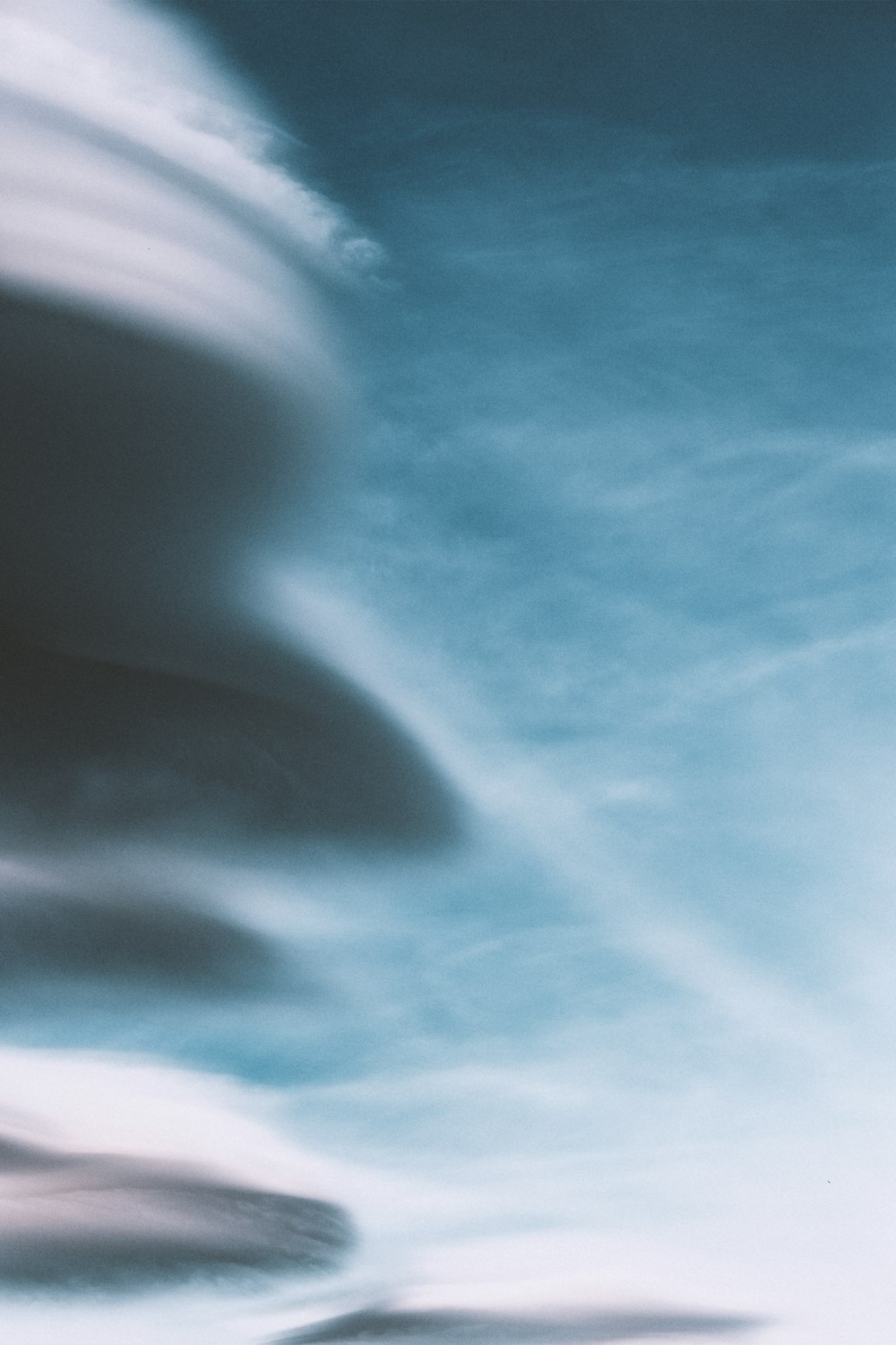 um avião voando através de um céu azul nublado