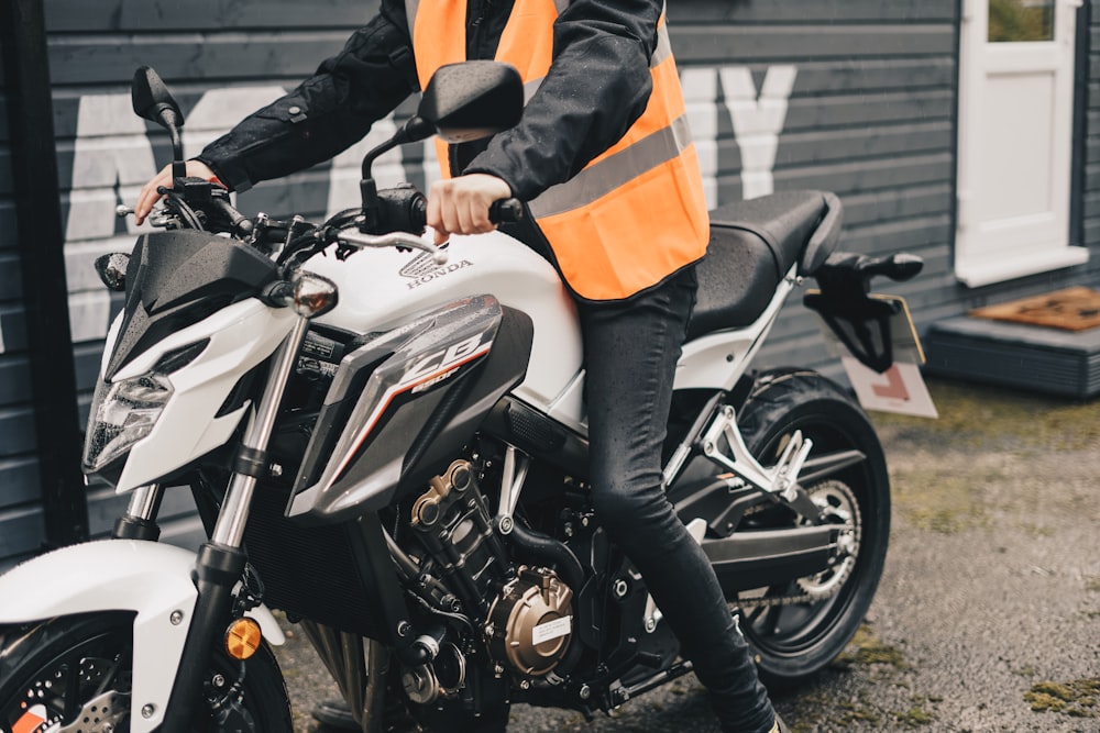 man riding white sports bike