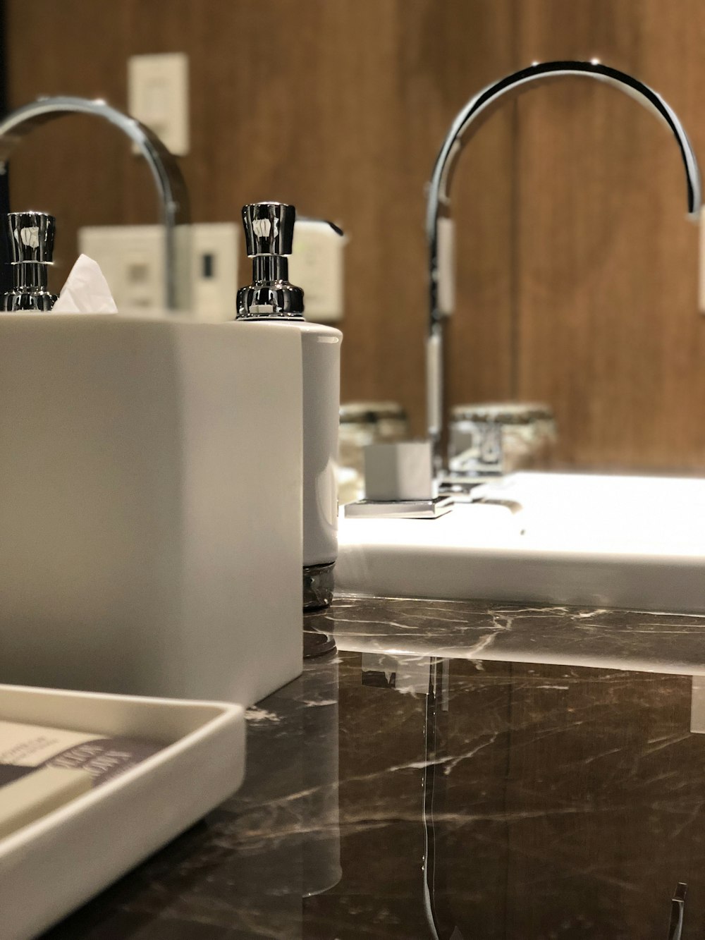 bathroom canisters beside stainless steel faucet