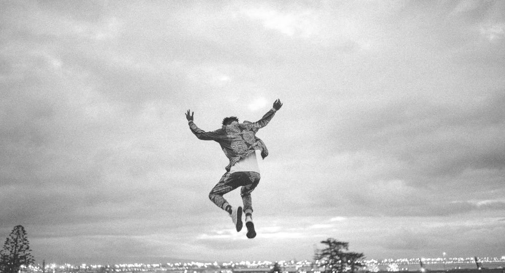 greyscale photo of person jumping