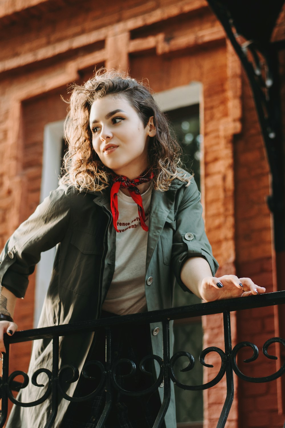 woman in grey button-up long-sleeved shirt standing near railings