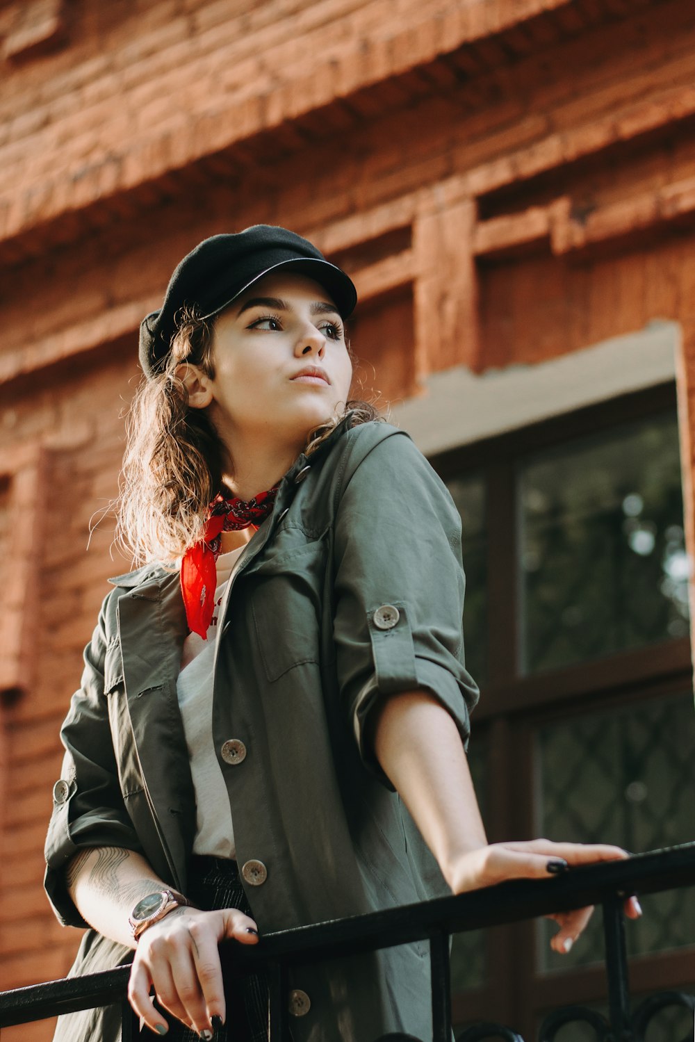 woman leaning on metal fence