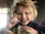 A smiling toddler enjoying a bowl of pudding in a bright, natural setting.