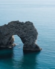 gray stone arch on body of water