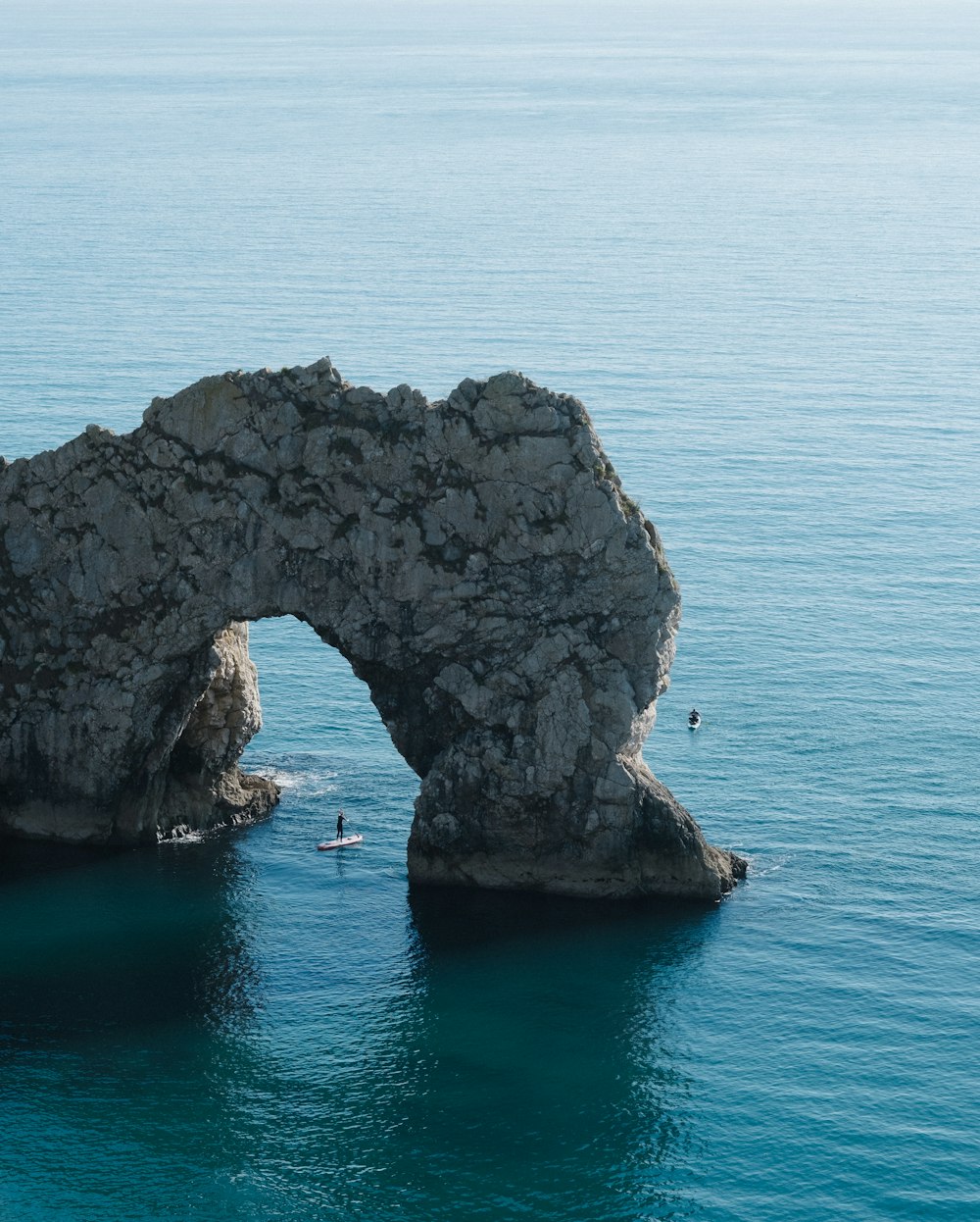 Arche en pierre grise sur plan d’eau