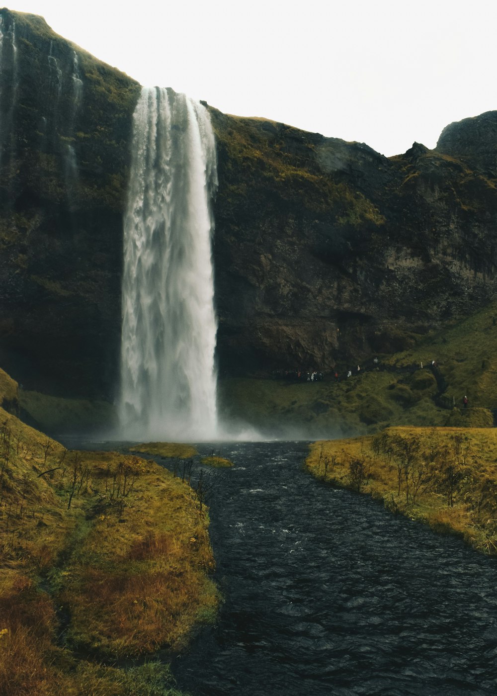 waterfalls surrounded by rocky mountains