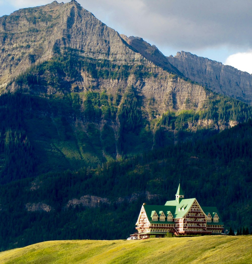 white and green building near mountain during daytime photo