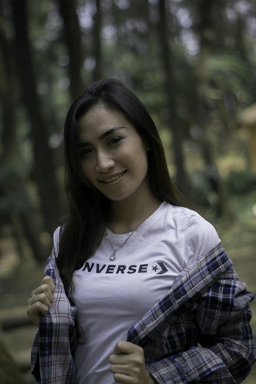 Model wearing a comfortable printed cotton t-shirt standing in a sunlit forest clearing.