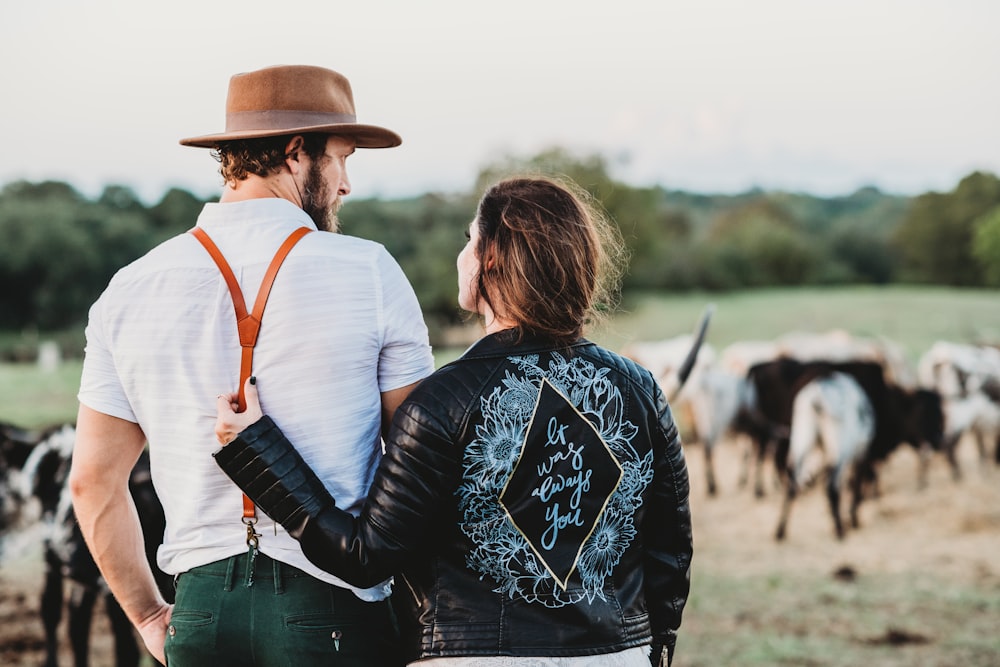 Homem e mulher no campo verde com gado