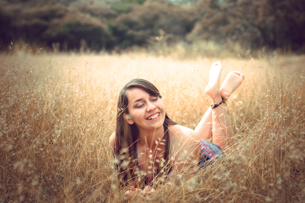 barefooted woman lying on brown grass field