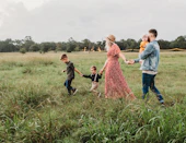 woman holding man and toddler hands during daytime