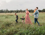 woman holding man and toddler hands during daytime