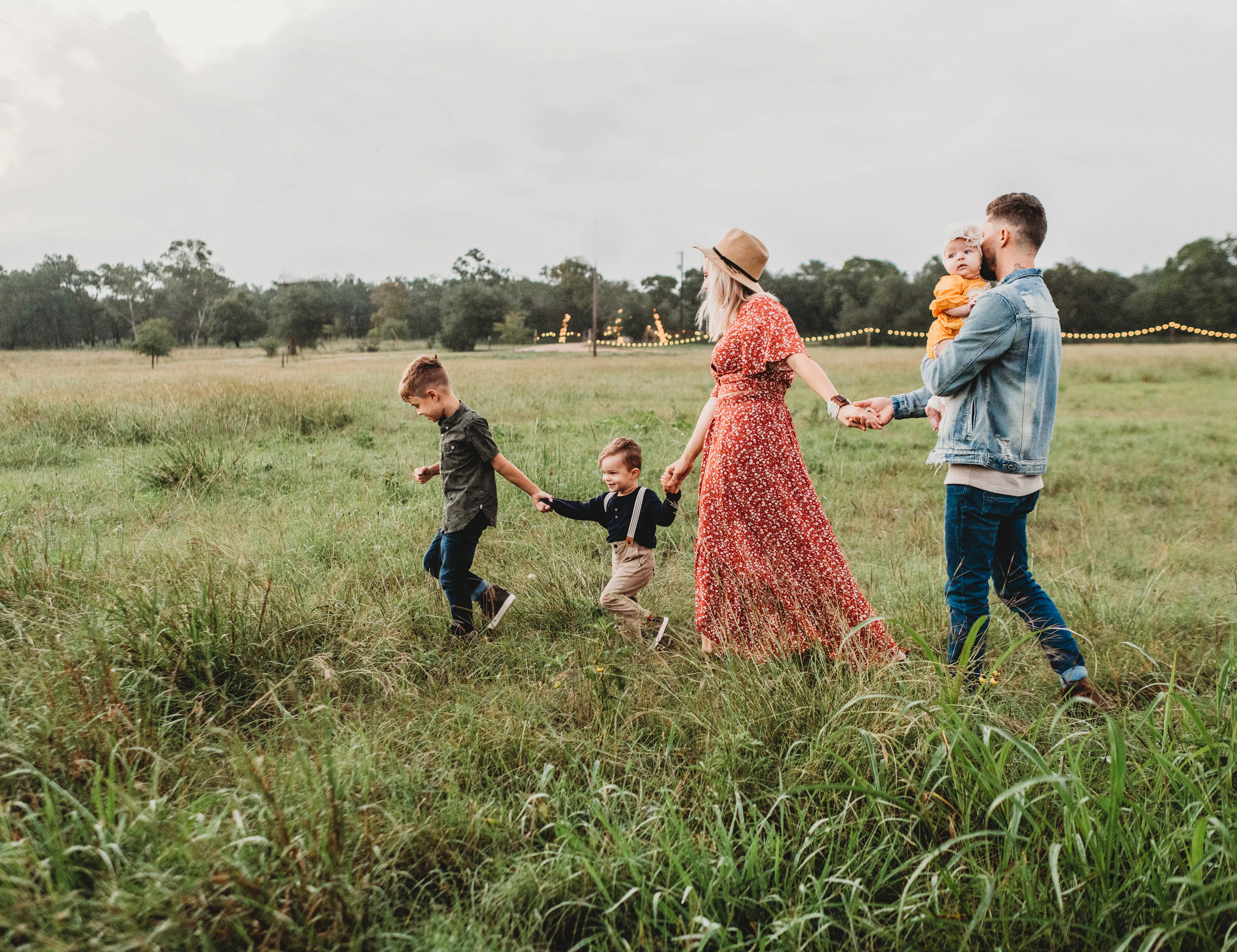 family of four walking on a sandy path with their backs to the camera