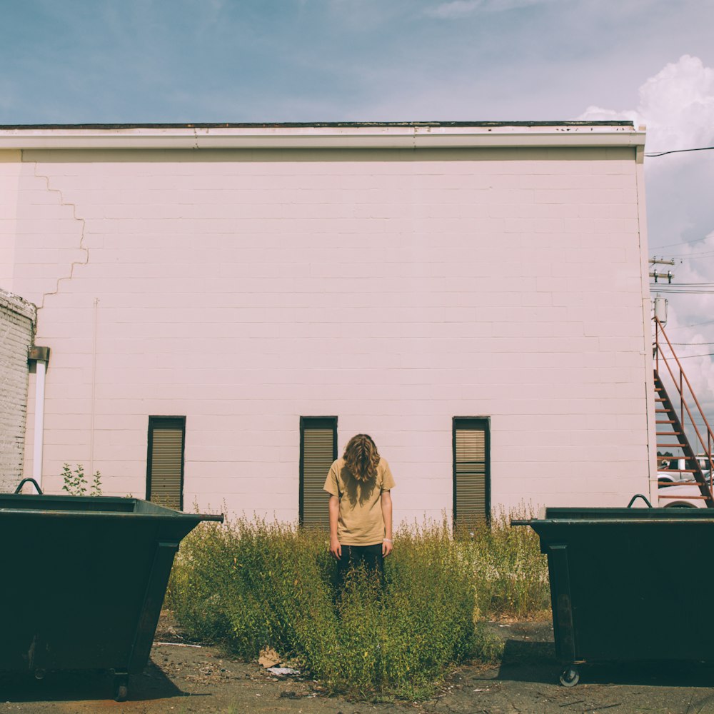 person standing near white concrete building during daytime