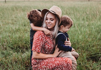 man and two children on grass field