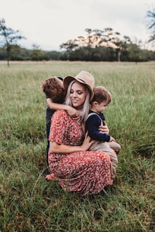man and two children on grass field