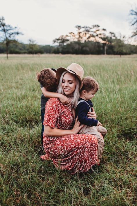 man and two children on grass field