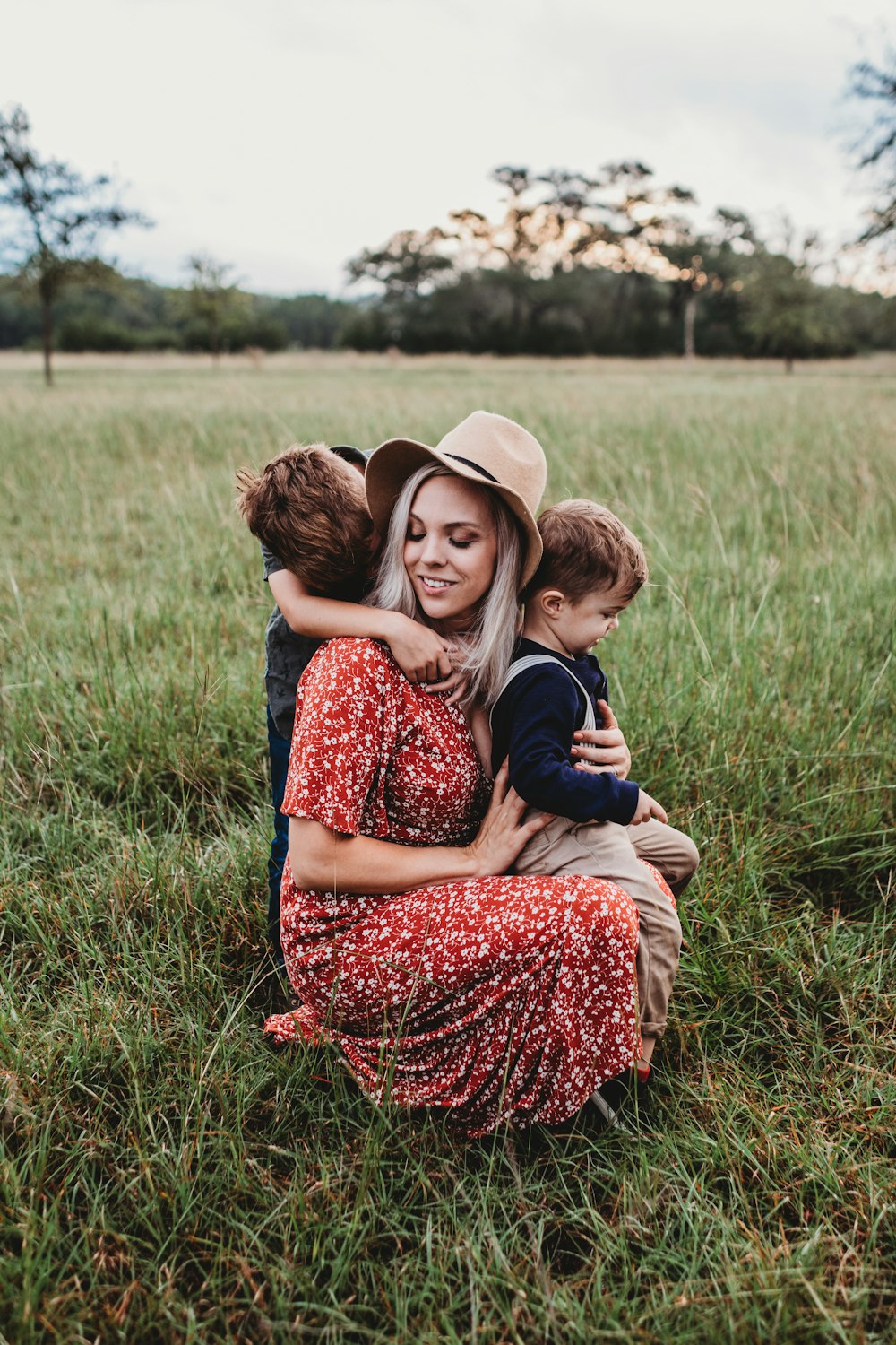 un homme et deux enfants sur un champ d’herbe