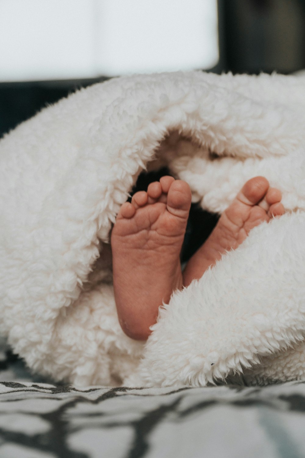 toddler wrapped in white blanket