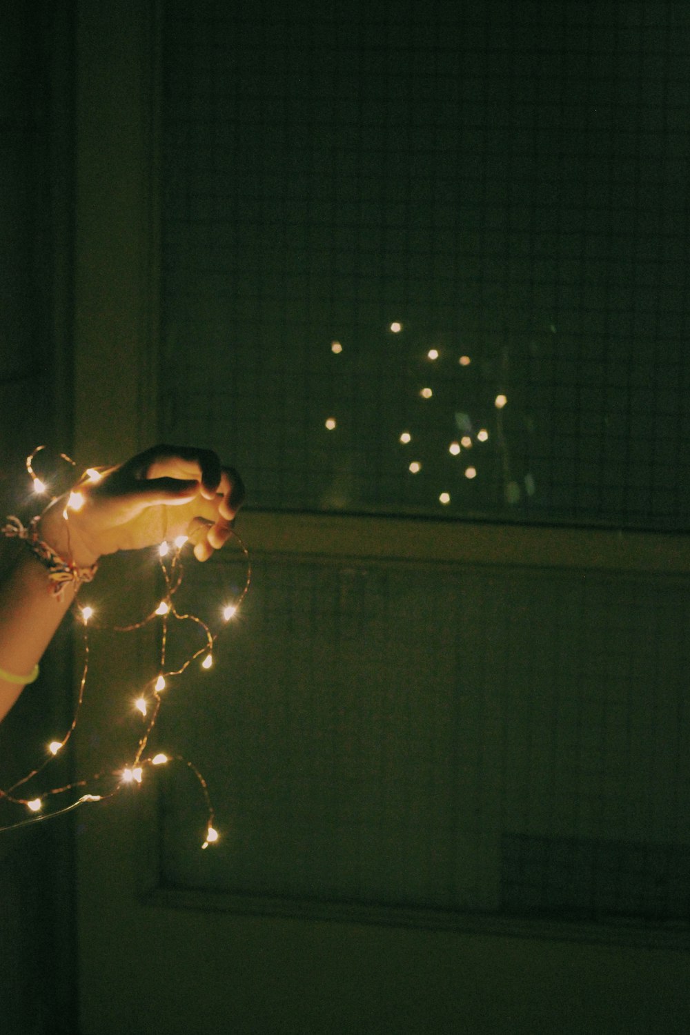person holding white string lights