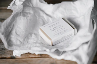 Minimalistic packaging of Bansparsh soaps arranged with natural elements like turmeric roots and aloe vera leaves.