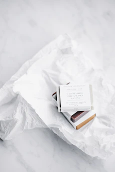 Elegant soap gift boxes tied with sage green ribbons set against a soft cream background.