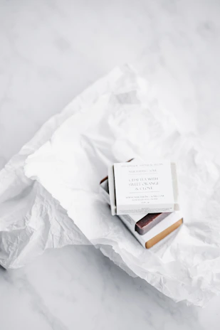 Close-up of a customer happily unboxing a neatly packaged baltamintis product in white minimal wrapping.