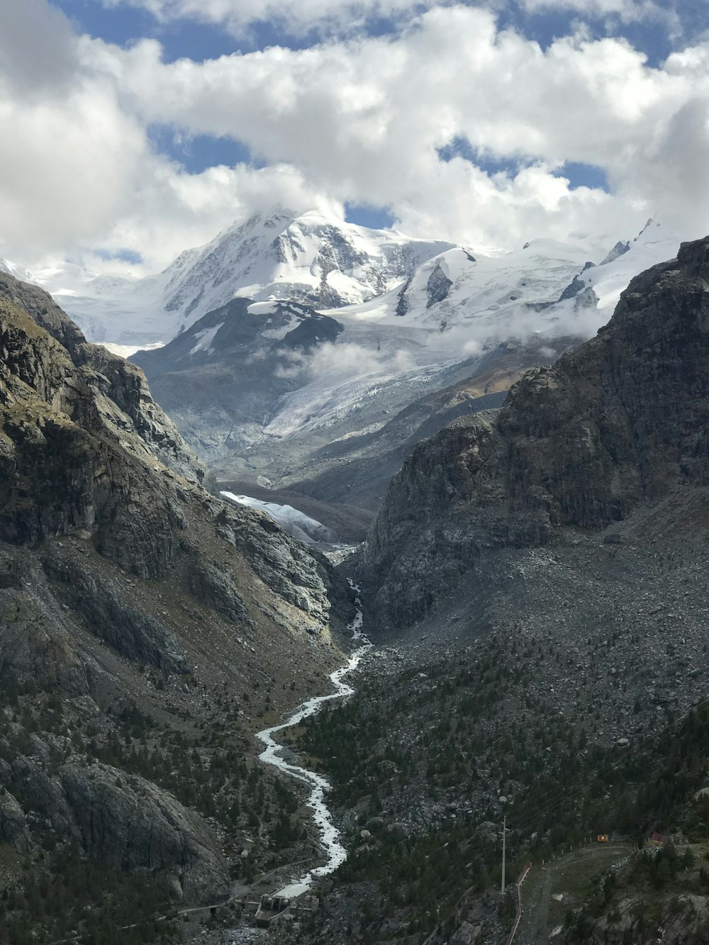 río entre montañas bajo cielos blancos y nublados durante el día