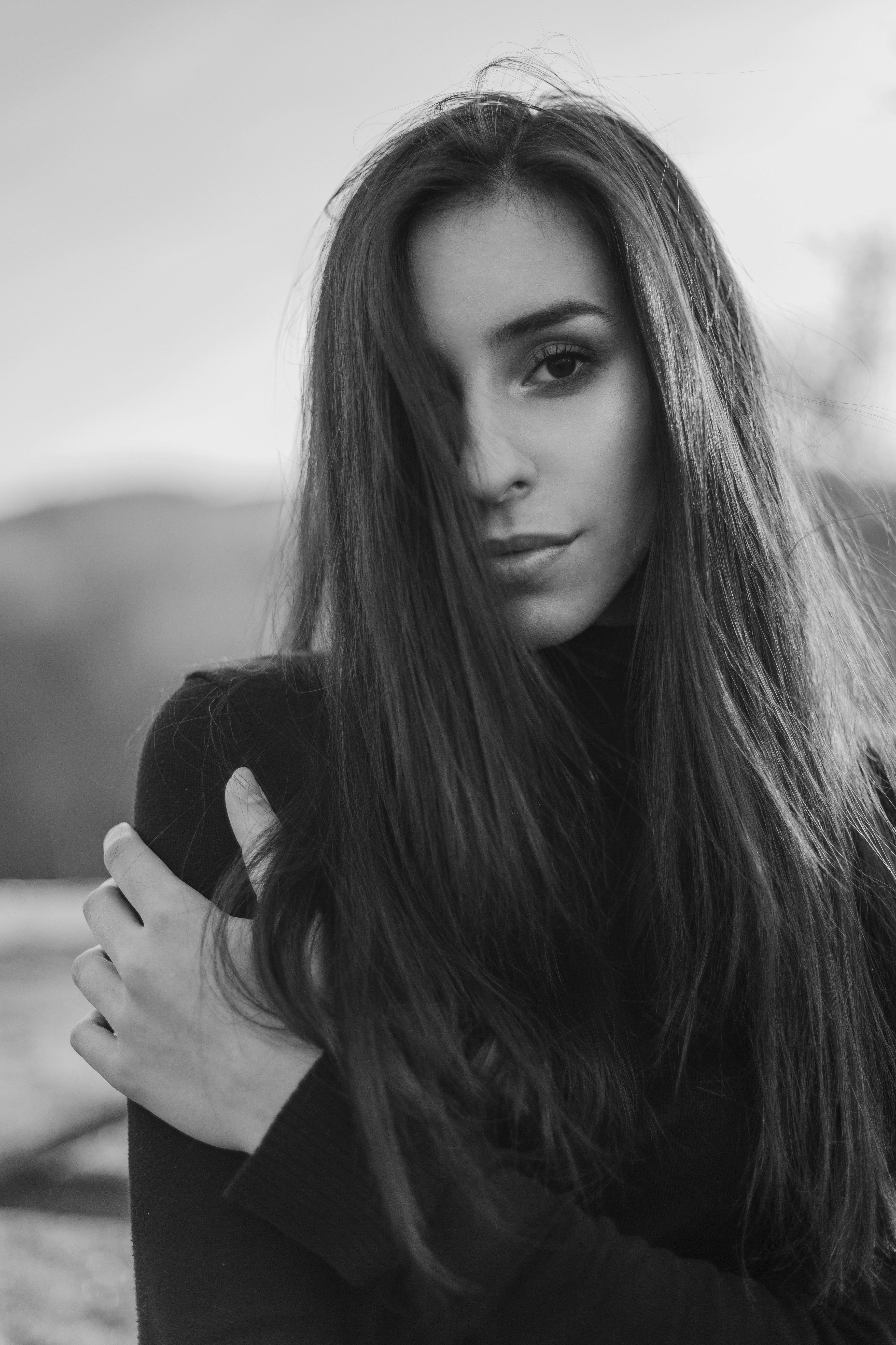 A woman with sleek, straight hair gazes softly at the camera, visually representing the natural feel and long-term comfort of high-quality hair extensions.