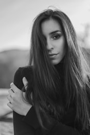 grayscale photography of woman touching here shoulder