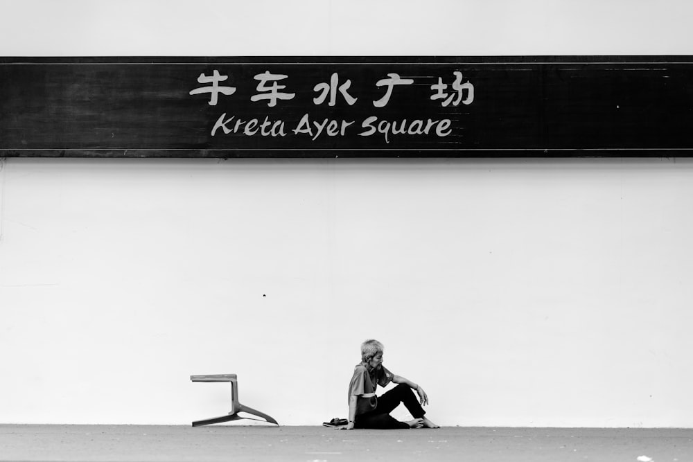 grayscale photo of woman sitting on the floor