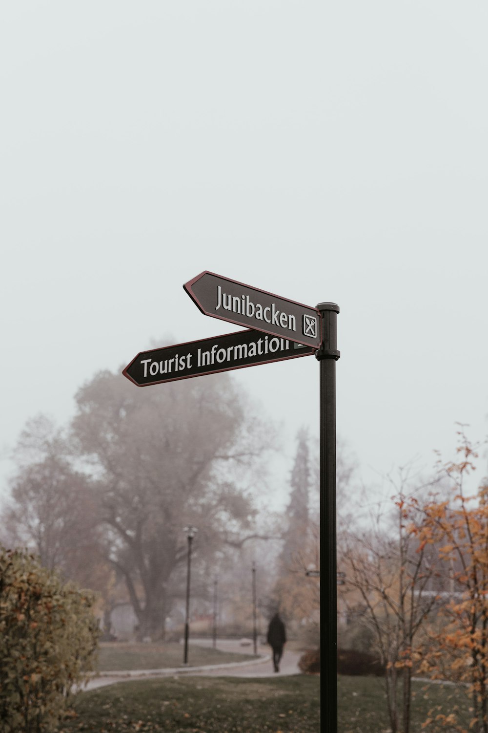 schwarzes Junibacken- und Touristeninformations-Straßenschild