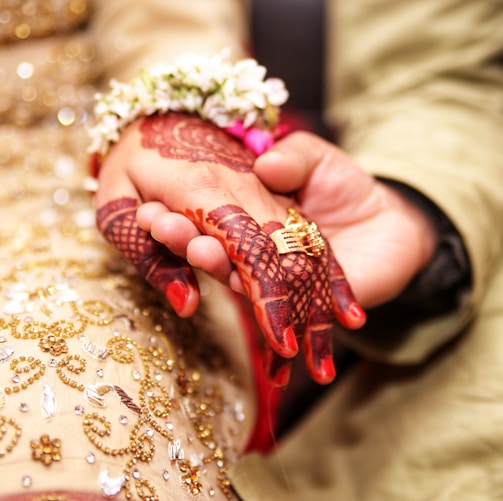 groom holding hands of his bride wearing wedding ring