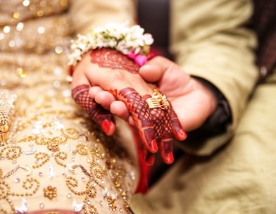 person holding hands wearing gold-colored ring