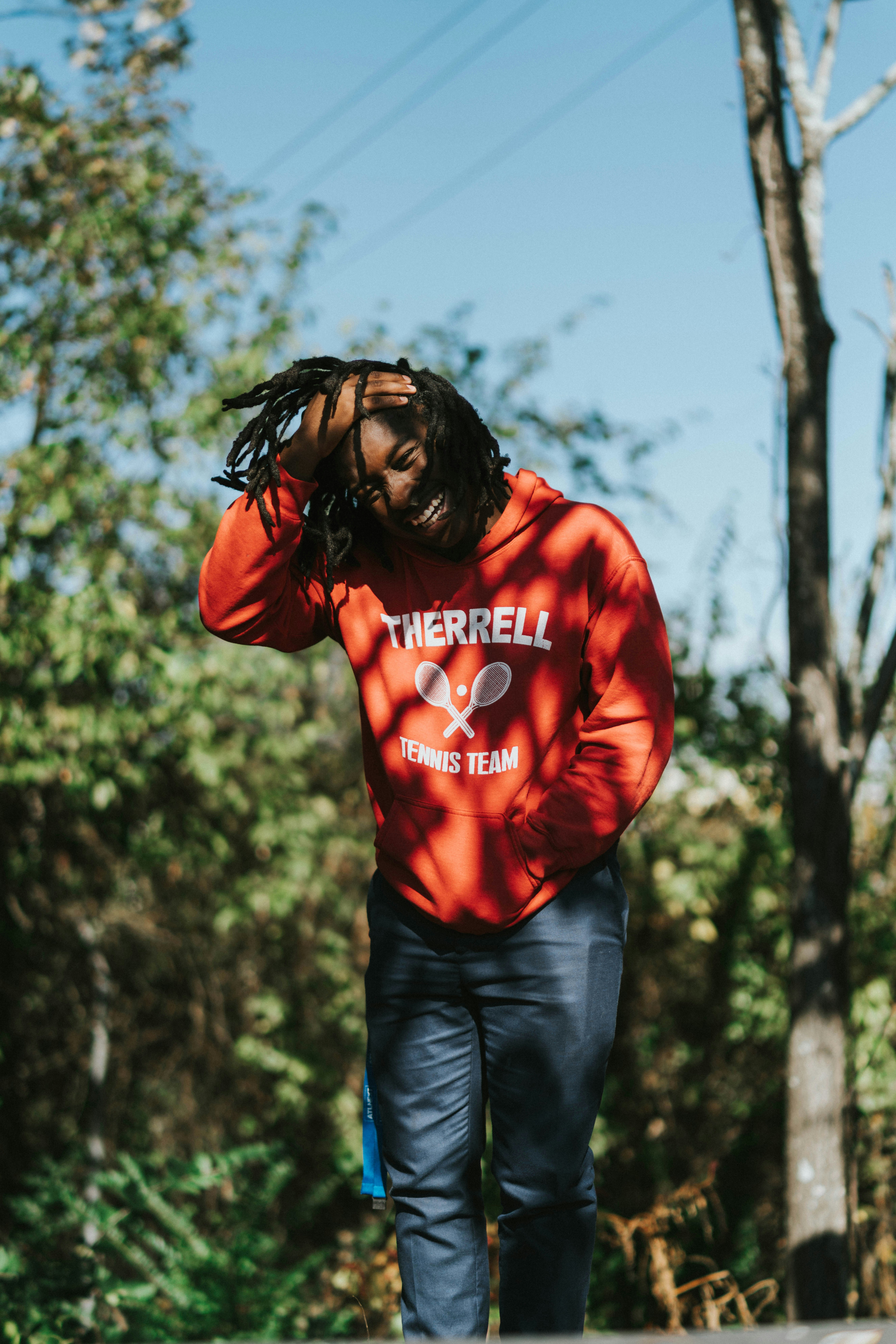 man laughing and touching own hair