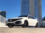 white Honda car parked near building