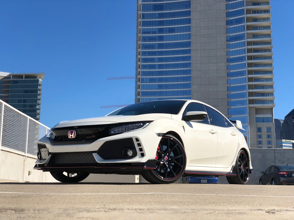 white Honda car parked near building