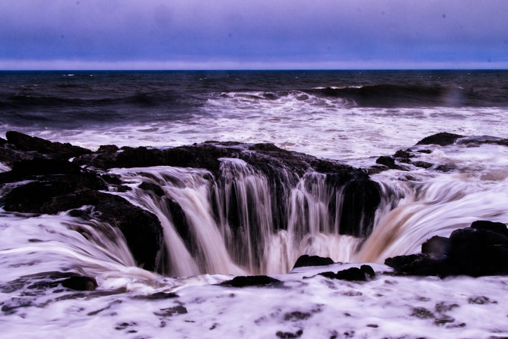 acqua di mare che cade in un buco roccioso in spiaggia