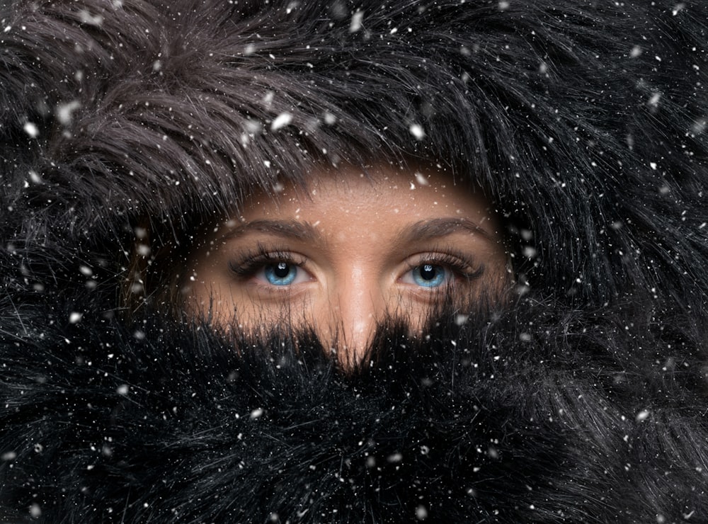 Mujer cubierta con pañuelo de piel negra durante el invierno