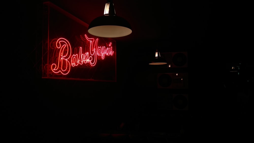 a red neon sign hanging from the side of a wall