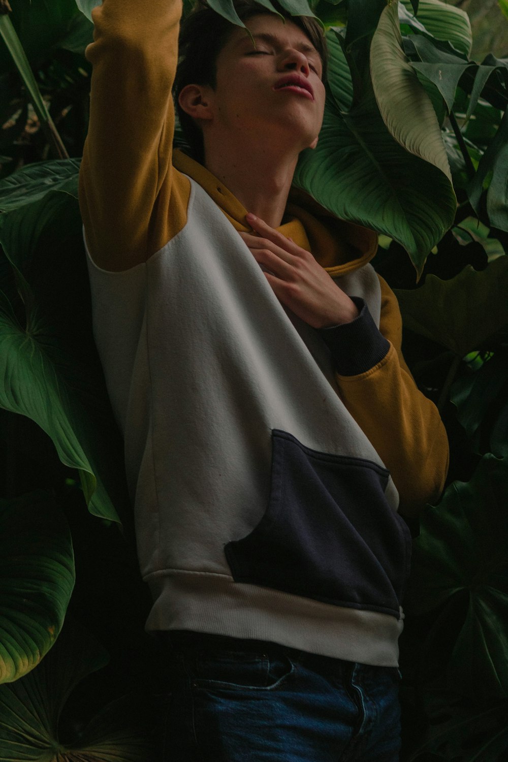 man standing beside green leaf plant during daytime