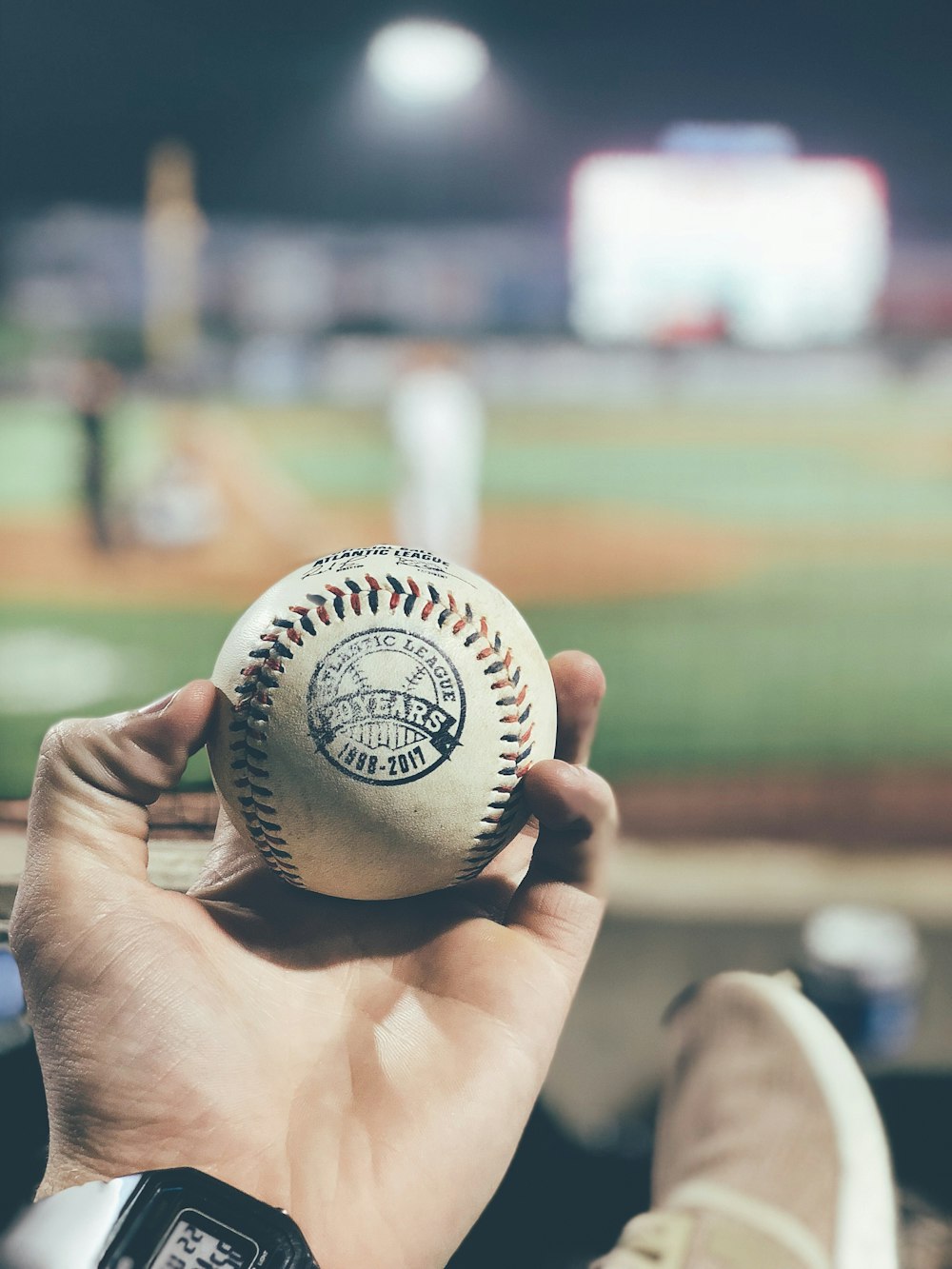 person holding white baseball