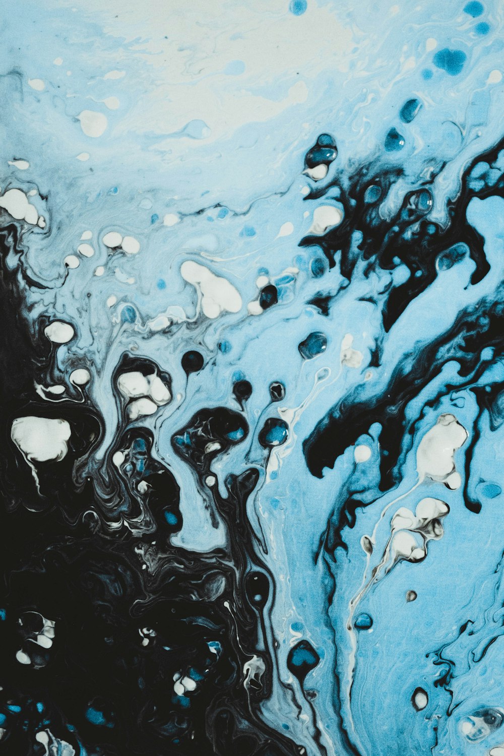 Un dipinto astratto blu e nero con bolle