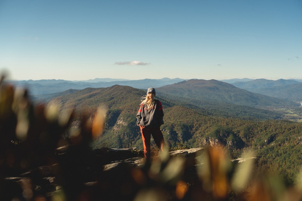 風景写真の山の崖の上に立つ女性
