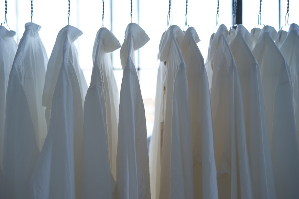 camisa de vestir blanca colgando de la ropa